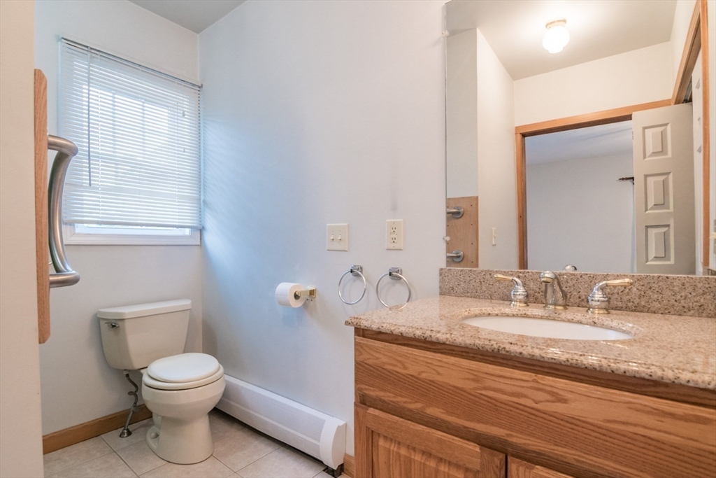 89 Potwine Lane Amherst, MA 01002 - Photo 30 of 37 a bathroom with a granite countertop toilet a sink and a mirror