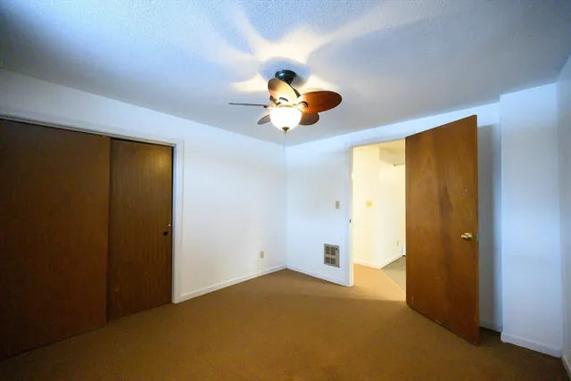 a view of an empty room with window and cabinet