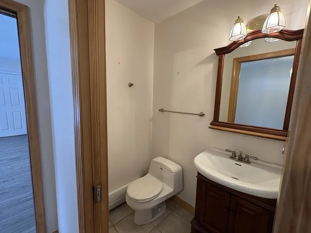 a bathroom with a granite countertop toilet a sink and a mirror