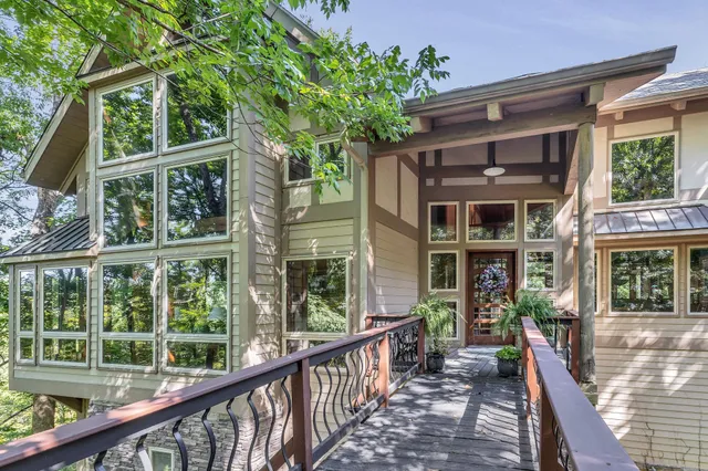 a view of house with a large windows and flower plants