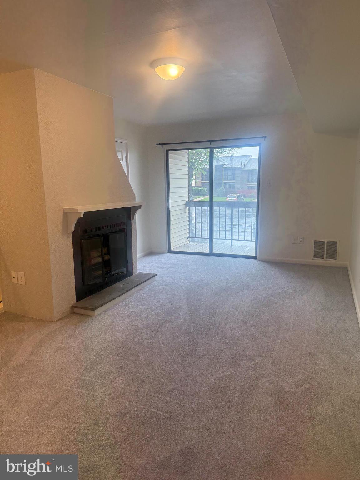 an empty room with fireplace and a window