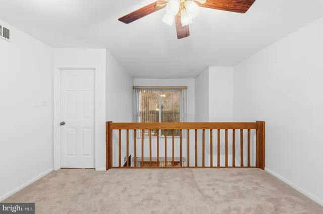 a view of an empty room with a ceiling fan