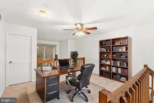a view of a workspace with furniture and a window