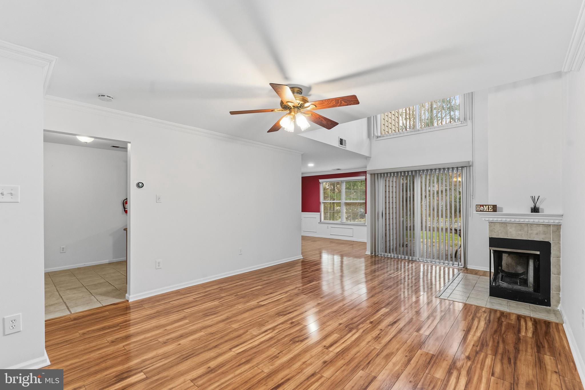 8 Brookline Court, Unit B Princeton, NJ 08540 - Photo 10 of 53 an empty room with wooden floor a ceiling fan a fireplace and windows