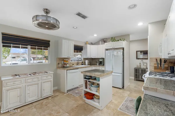 a kitchen with stainless steel appliances kitchen island granite countertop a sink and cabinets