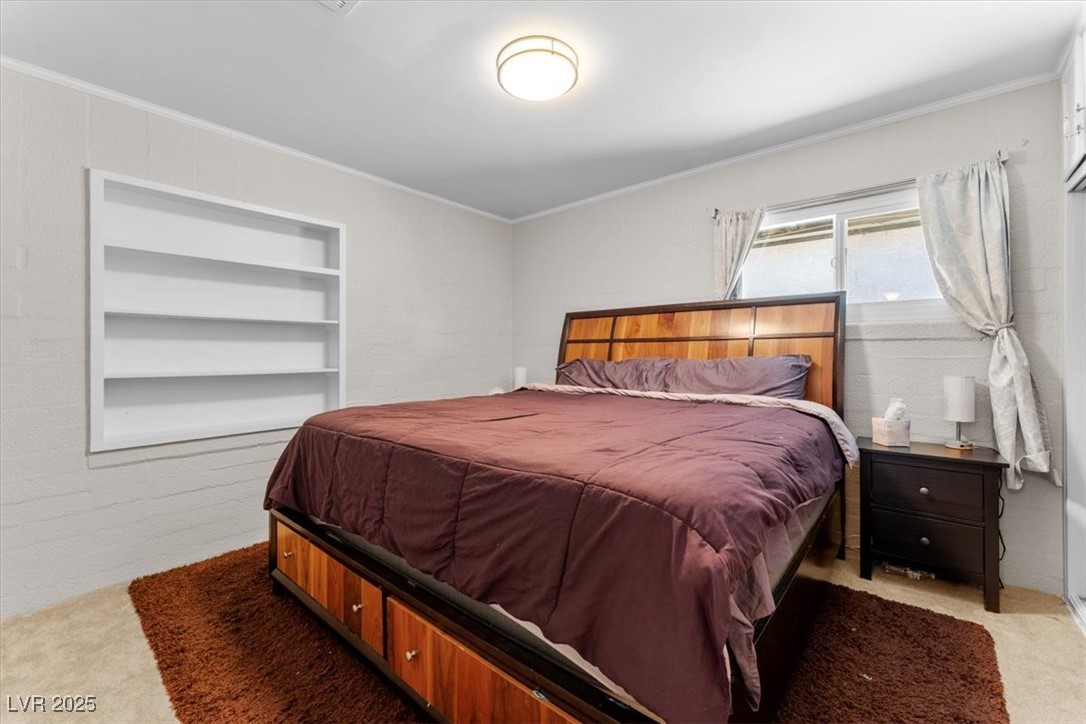 556 7th Street Boulder City, NV 89005 - Photo 18 of 37 Bedroom with light colored carpet and ornamental molding