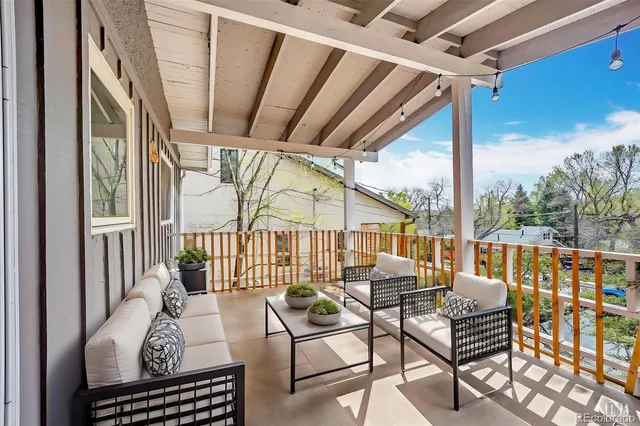 a view of a patio with a table and chairs and wooden fence