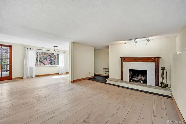wooden floor fireplace and windows in an empty room