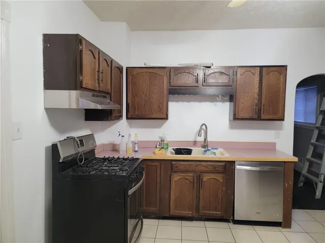 a kitchen with stainless steel appliances a sink stove and cabinets