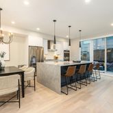 a kitchen with stainless steel appliances kitchen island granite countertop a table chairs and a refrigerator