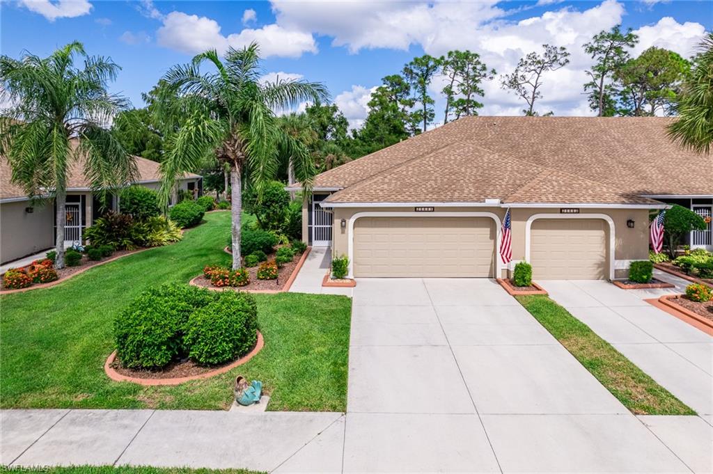 a front view of a house with a yard and potted plants