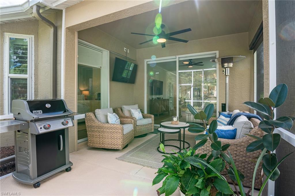 21441 Knighton Run Estero, FL 33928 - Photo 29 of 50 a living room with furniture and a floor to ceiling window