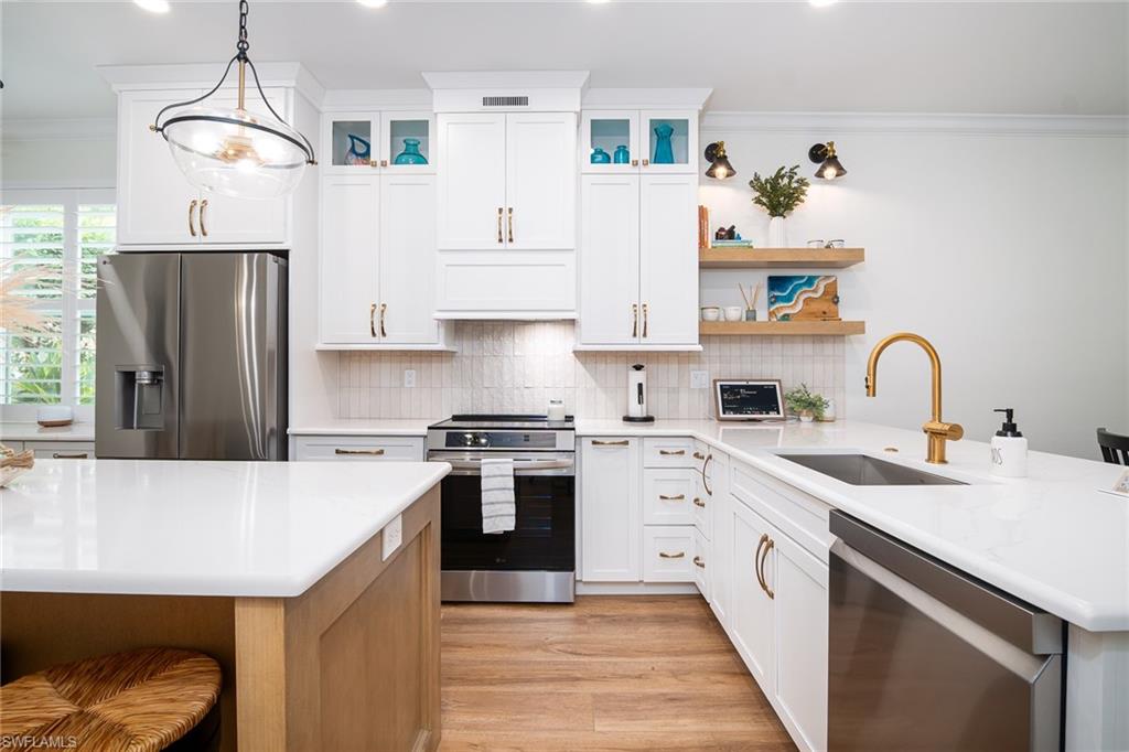 21441 Knighton Run Estero, FL 33928 - Photo 10 of 50 a kitchen with a sink a refrigerator and cabinets