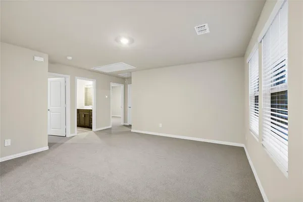 an empty room with a window and a kitchen
