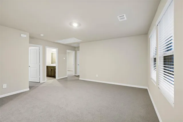 an empty room with a window and a kitchen