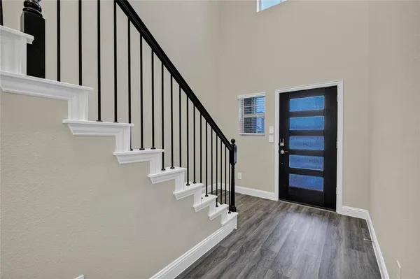 a view of staircase with wooden floor and white walls