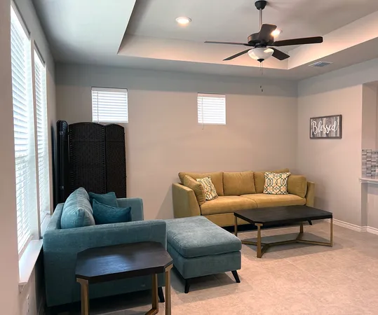 a living room with furniture and a ceiling fan