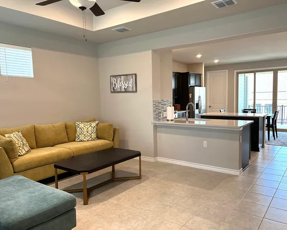 a living room with a couch and a view of kitchen