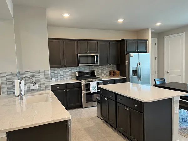 a kitchen with a sink a stove a refrigerator a center island and a oven