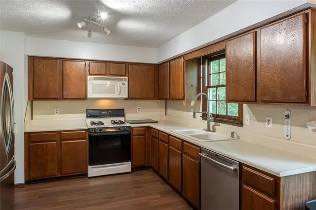 a kitchen with stainless steel appliances granite countertop a sink stove and cabinets