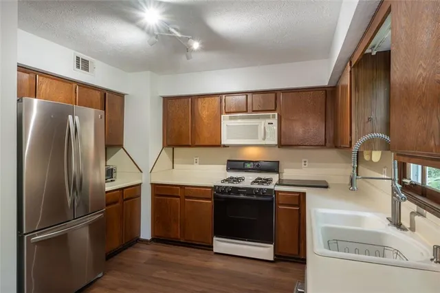 a kitchen with stainless steel appliances granite countertop a stove a sink and a refrigerator