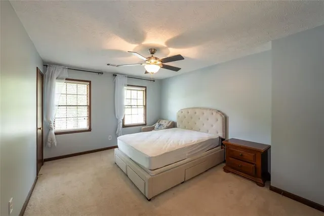 a spacious bedroom with a bed and a chandelier