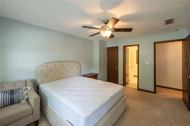 a bedroom with a bed and ceiling fan