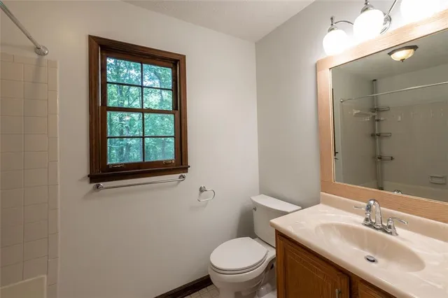 a bathroom with a sink a toilet and a window