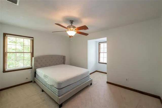 a bedroom with a bed chandelier and a window