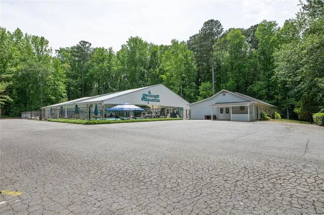 a front view of a house with a yard and trees in the background