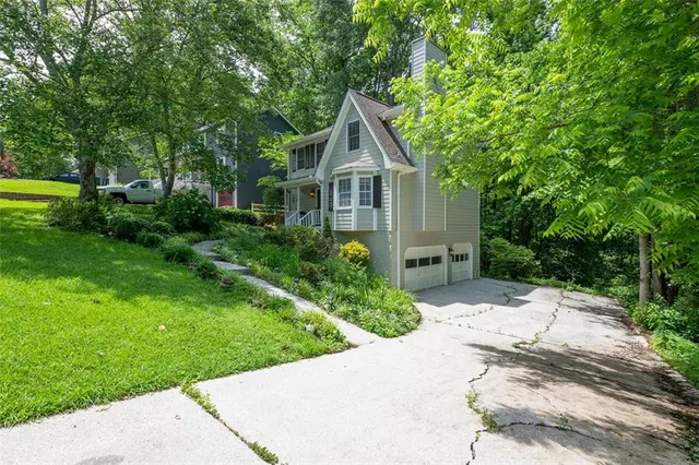 a front view of a house with a yard and trees