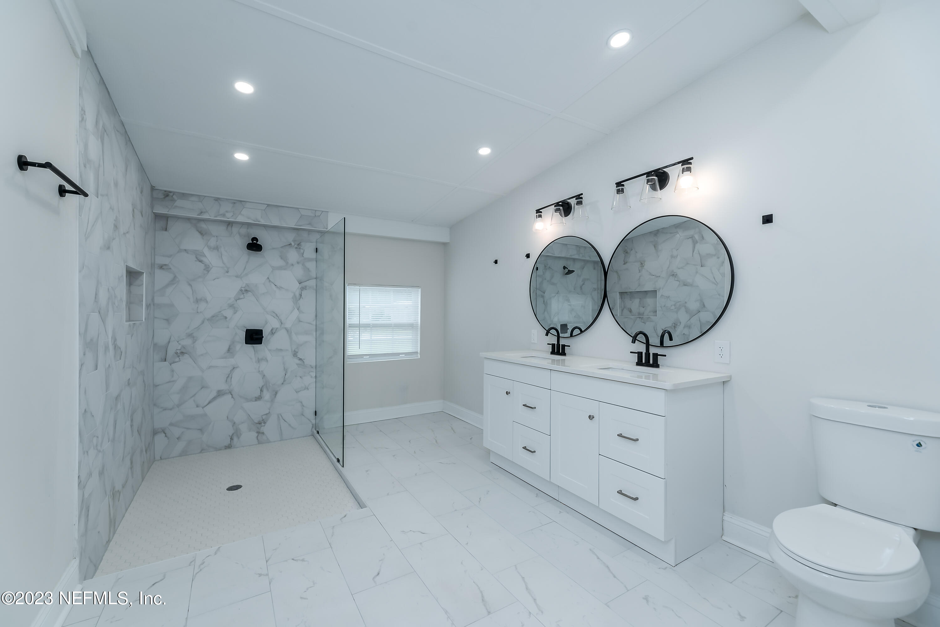 a bathroom with a toilet a sink a mirror and vanity