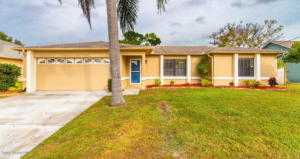 731 Raleigh Road Southeast Palm Bay, FL 32909 - Photo 2 of 36 a front view of a house with a garden and patio