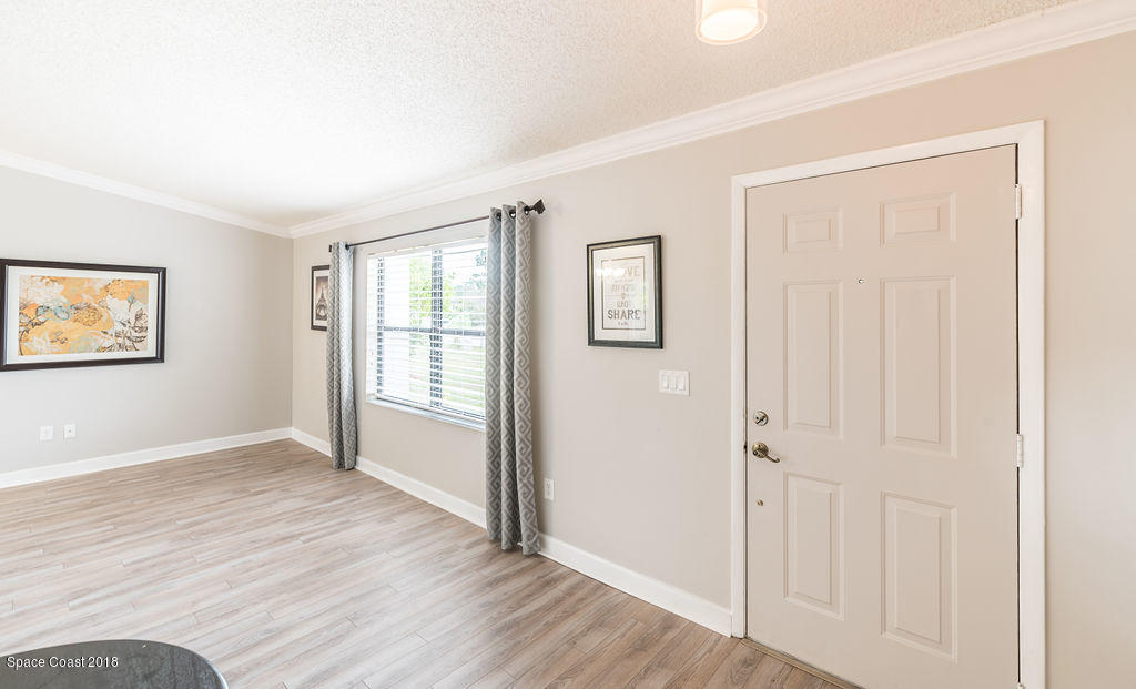 731 Raleigh Road Southeast Palm Bay, FL 32909 - Photo 11 of 36 an empty room with wooden floor and windows