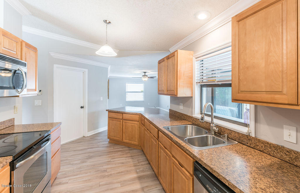 731 Raleigh Road Southeast Palm Bay, FL 32909 - Photo 14 of 36 a kitchen with stainless steel appliances granite countertop a sink a stove and a wooden floors