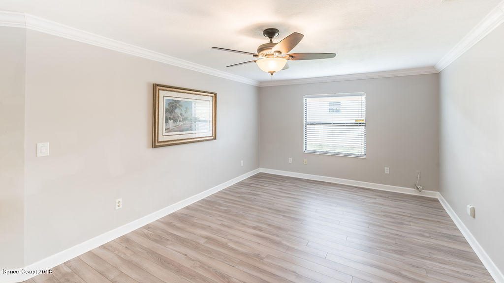 731 Raleigh Road Southeast Palm Bay, FL 32909 - Photo 18 of 36 a view of an empty room with wooden floor and a window