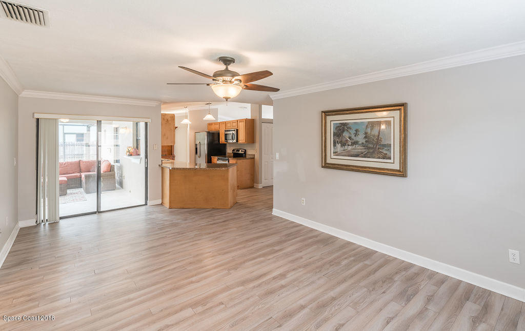 731 Raleigh Road Southeast Palm Bay, FL 32909 - Photo 19 of 36 a view of a livingroom with wooden floor and a ceiling fan
