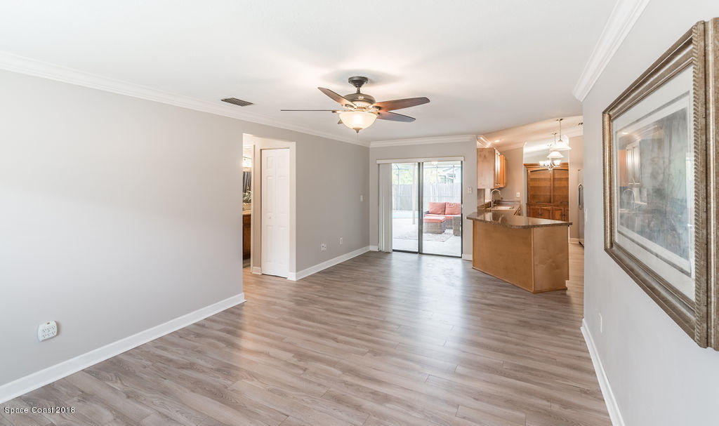 731 Raleigh Road Southeast Palm Bay, FL 32909 - Photo 20 of 36 an empty room with wooden floor a ceiling fan and windows