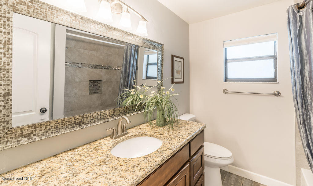 731 Raleigh Road Southeast Palm Bay, FL 32909 - Photo 27 of 36 a bathroom with a granite countertop sink toilet and shower