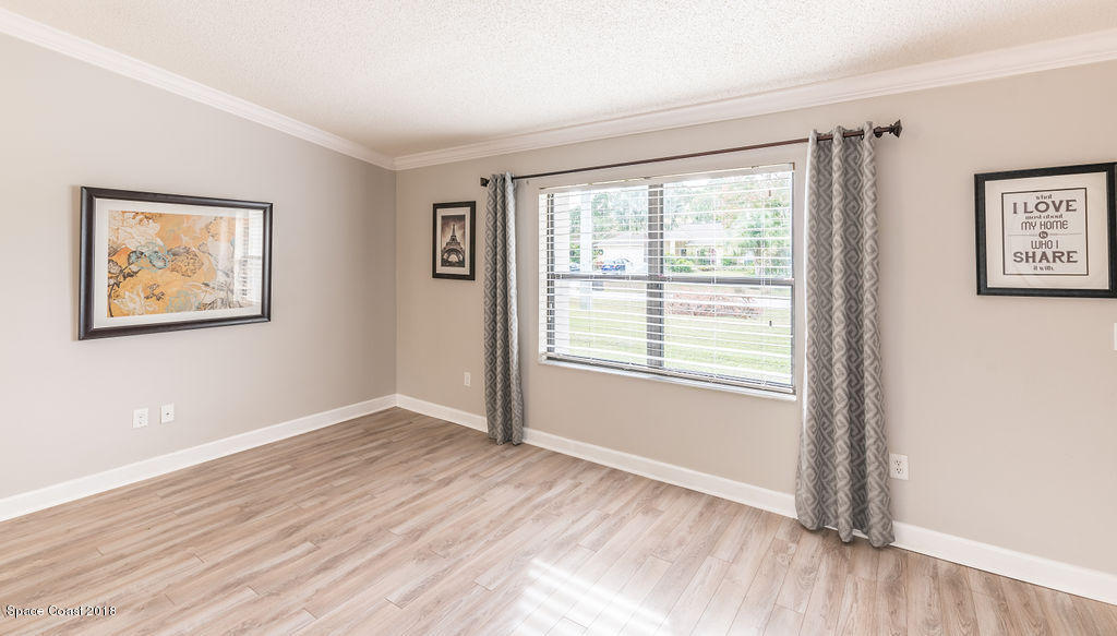 731 Raleigh Road Southeast Palm Bay, FL 32909 - Photo 7 of 36 a view of an empty room with wooden floor and a window