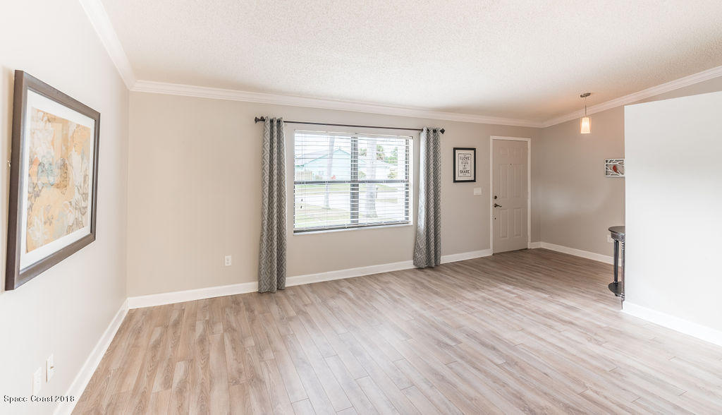 731 Raleigh Road Southeast Palm Bay, FL 32909 - Photo 8 of 36 an empty room with wooden floor and windows