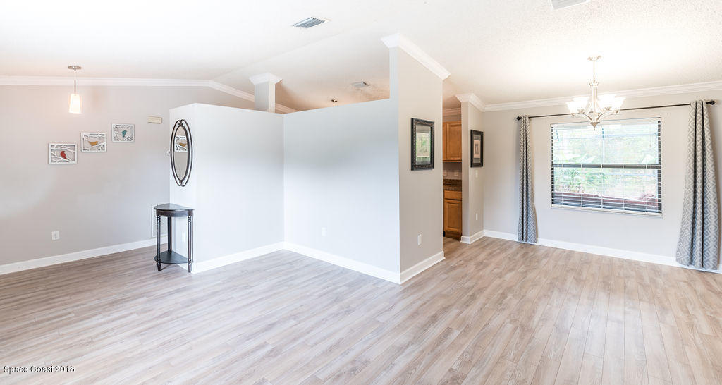 731 Raleigh Road Southeast Palm Bay, FL 32909 - Photo 10 of 36 wooden floor in an empty room with a window