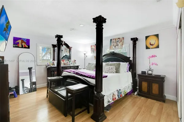 a bedroom with a bed and wooden floor