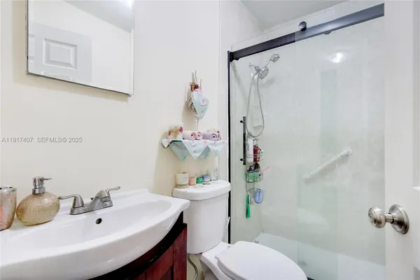 a bathroom with a sink mirror vanity and toilet