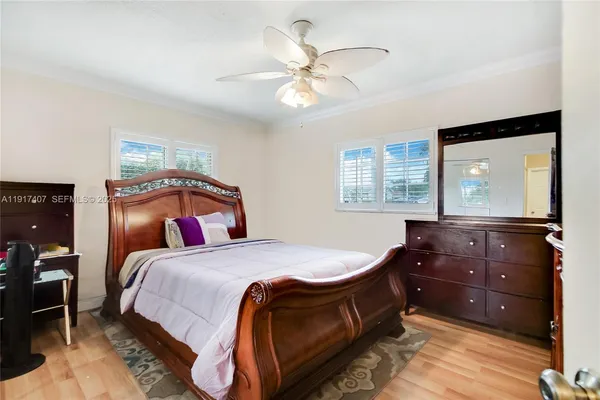 a bedroom with a bed and a mirror on dresser