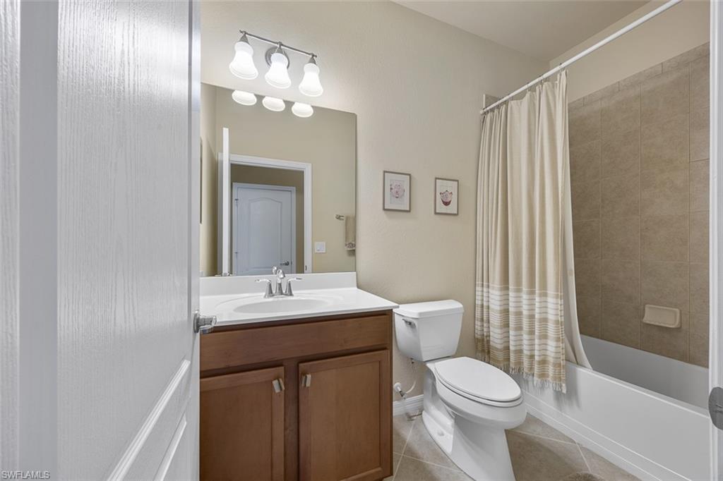 11693 Eros Road Lehigh Acres, FL 33971 - Photo 12 of 21 a bathroom with a toilet a sink a tub and mirror