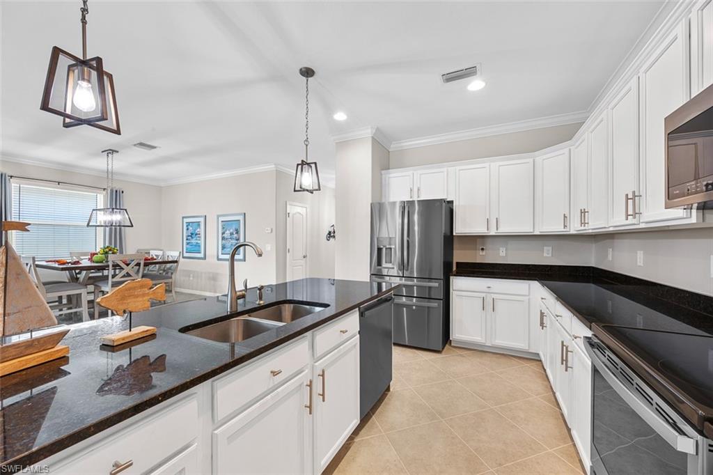 11693 Eros Road Lehigh Acres, FL 33971 - Photo 4 of 21 a kitchen with granite countertop a sink a counter space appliances and cabinets