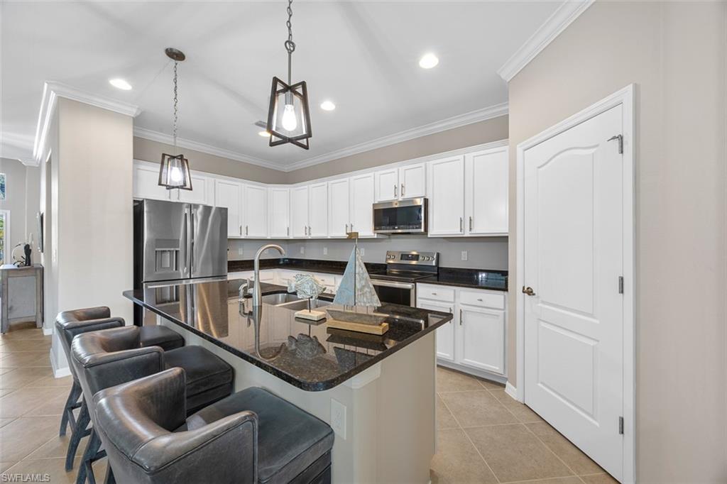 11693 Eros Road Lehigh Acres, FL 33971 - Photo 6 of 21 a kitchen with stainless steel appliances granite countertop a sink and refrigerator