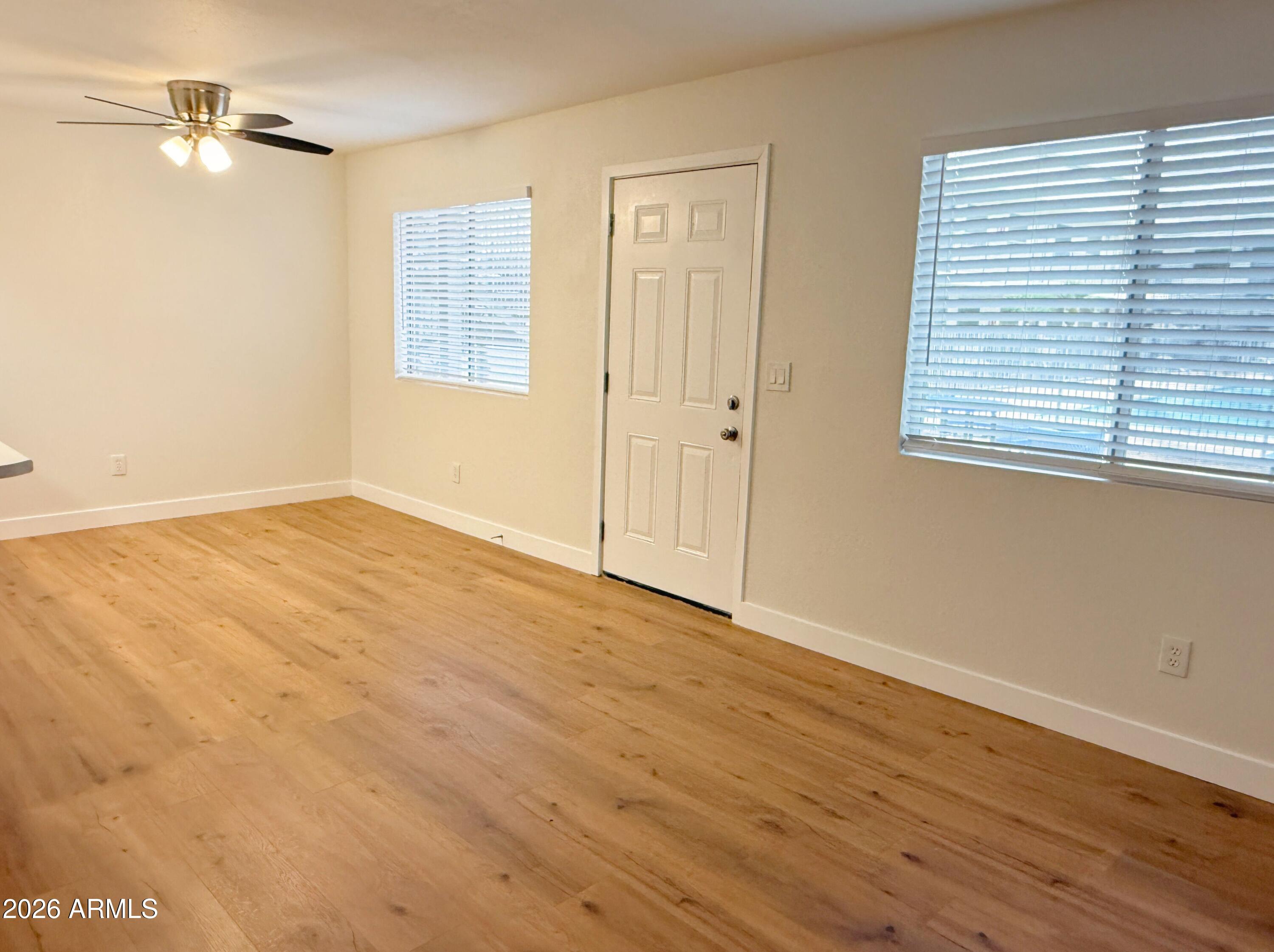 18202 North Cave Creek Road, Unit 148 Phoenix, AZ 85032 - Photo 6 of 19 a view of an empty room with wooden floor and a window
