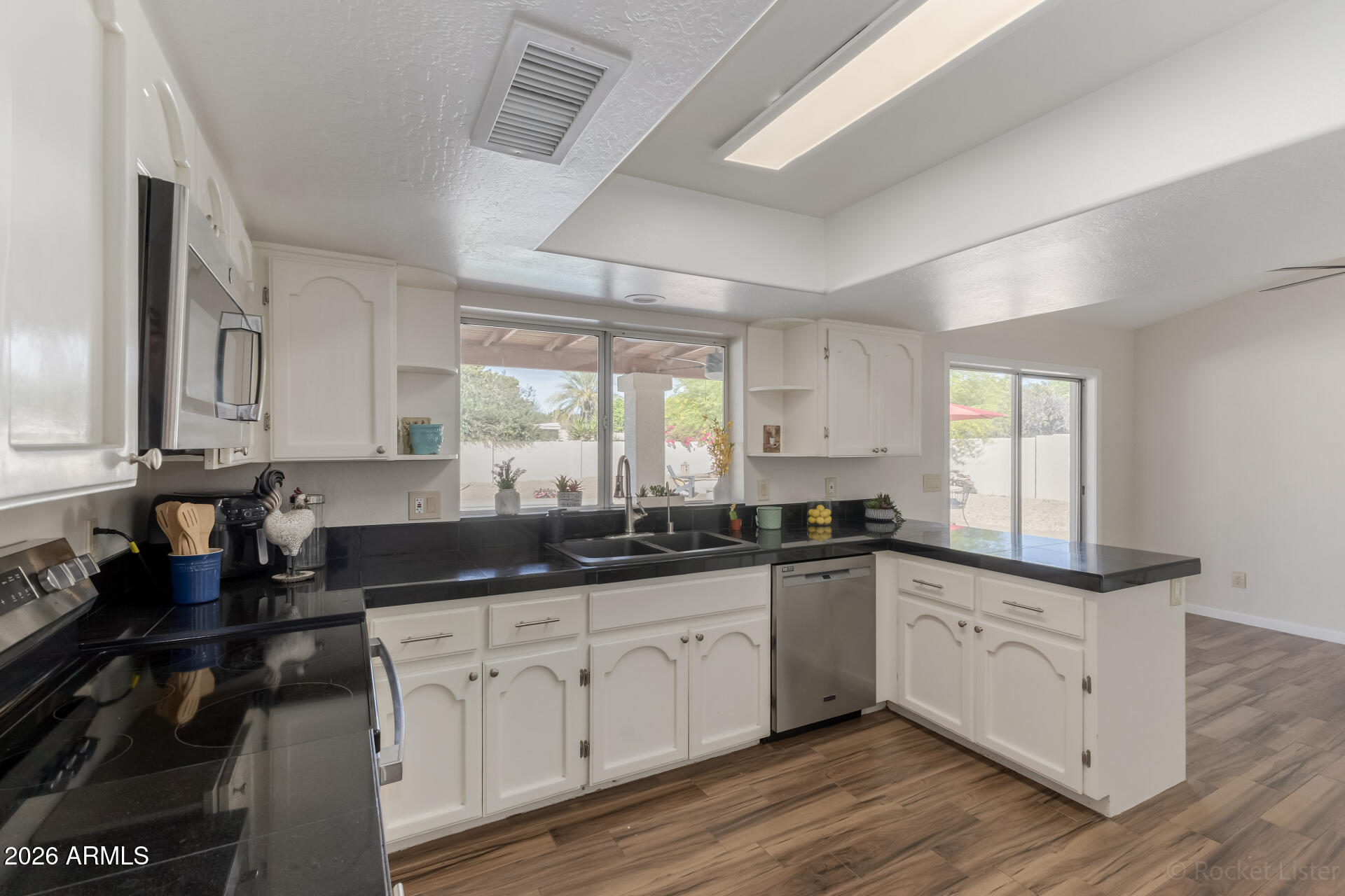 5116 East Wethersfield Road Scottsdale, AZ 85254 - Photo 17 of 53 a kitchen with granite countertop a sink and cabinets